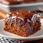 Slice of moist Dr. Pepper Cake topped with chocolate icing