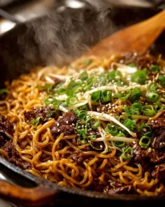 Bowl of quick Asian beef ramen noodles garnished with vegetables