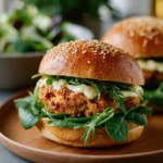 Avocado Salmon Burger on a plate with fresh ingredients
