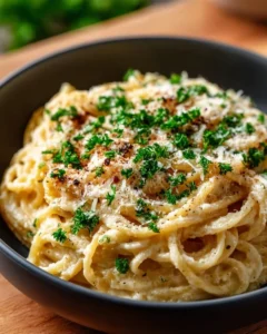 Plate of creamy garlic parmesan spaghetti with herbs and cheese