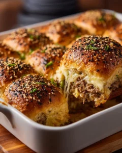 Philly cheesesteak sliders on a platter with toppings