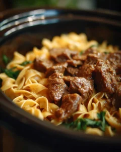Delicious Crockpot Beef Stroganoff served with pasta and garnished with parsley