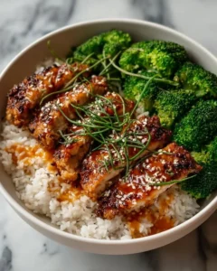 Delicious sticky chicken rice bowls topped with fresh herbs and vegetables