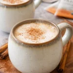A delicious chai tea latte topped with foam and spices in a cozy café setting.