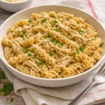 Crockpot garlic parmesan chicken pasta served in a bowl with garnish.