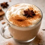A steaming cup of homemade chai latte with spices and frothy milk