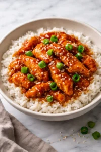 Honey garlic slow cooker chicken thighs garnished with herbs on a plate.