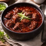 Bowl of Ultimate Texas Red Chili with toppings on a rustic table