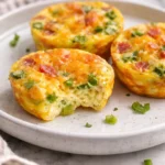 Easy egg bites served on a plate with vegetables and cheese