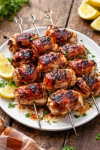 Grilled bacon wrapped chicken skewers garnished and ready to serve