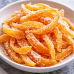 Homemade candied orange peels on a white plate