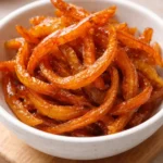 Homemade candied orange peels in a glass jar on a wooden table