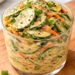 Creamy Asian cucumber salad bowl with fresh ingredients and vibrant colors