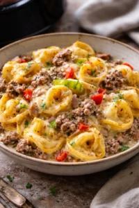Crock Pot cheesesteak tortellini dish served in a bowl with toppings