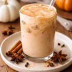 Delicious iced pumpkin cream chai tea latte topped with whipped cream and spices