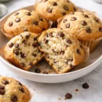 Delicious sourdough chocolate chip muffins on a wooden table.