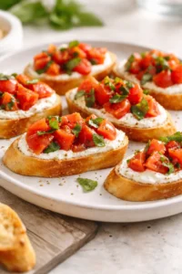 Whipped feta tomato crostini topped with fresh tomatoes and herbs
