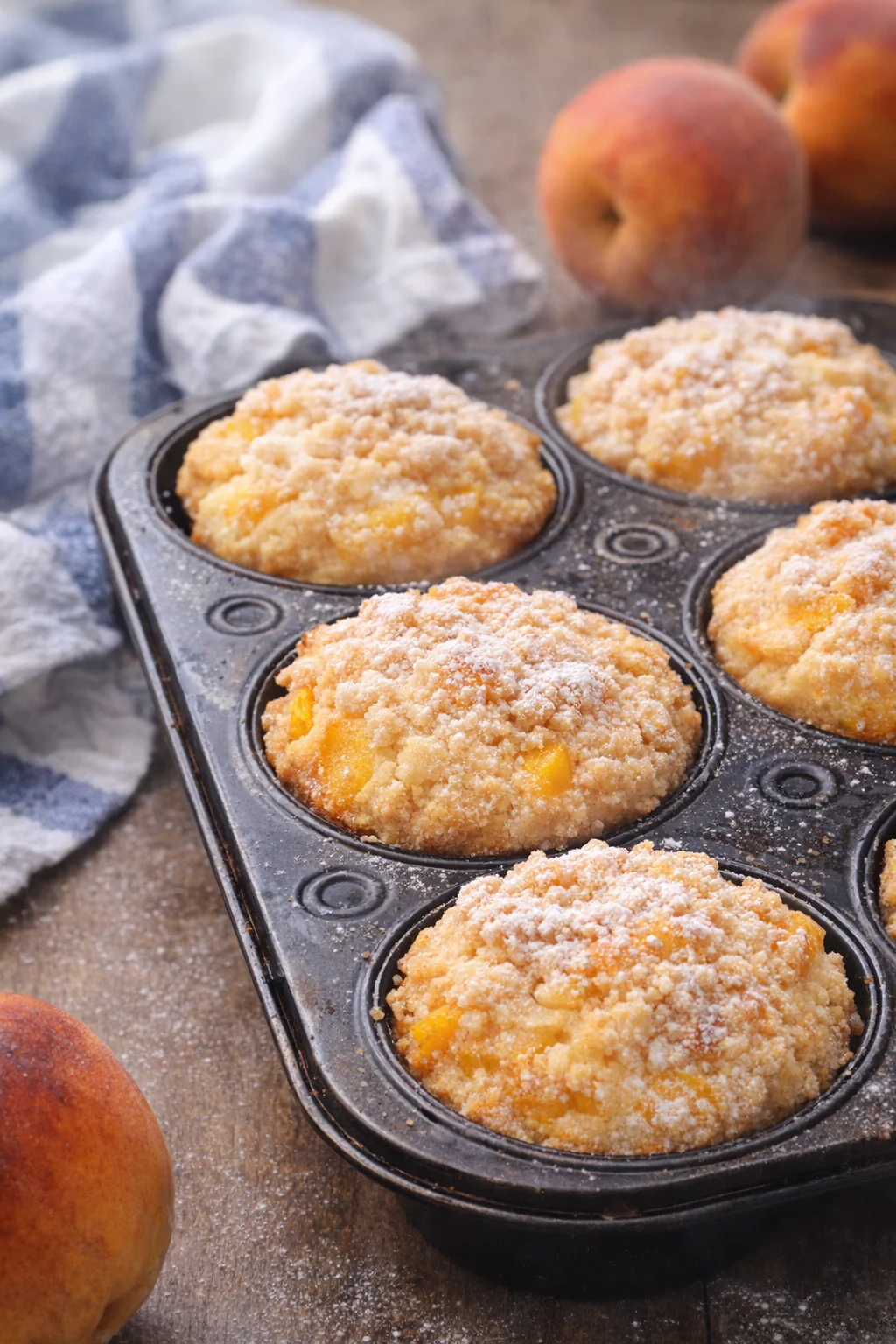 Delicious peach cobbler muffins fresh out of the oven with juicy peach filling