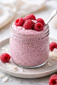 Homemade Raspberry Chia Pudding in a bowl with fresh raspberries on top.