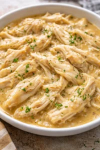 Crockpot Chicken and Gravy served with mashed potatoes and vegetables.