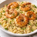 Delicious shrimp orzo in creamy wine sauce on a plate