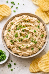 Brandied caramelized onion dip served in a bowl with crackers