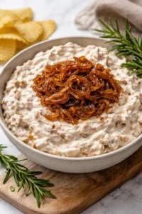 Delicious caramelized onion dip served with fresh vegetables and chips