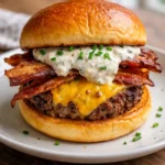 Loaded ranch burger topped with bacon and cheese, served on a gourmet bun.
