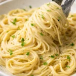 Delicious bowl of Garlic Parmesan Pasta with fresh herbs and grated cheese
