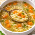 Bowl of delicious homemade Orzo Soup with vegetables and herbs